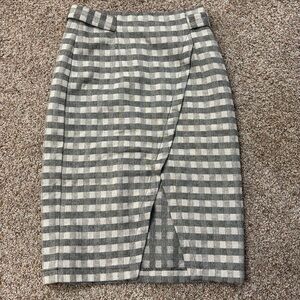 Mid length plaid skirt with buckle design at waist.